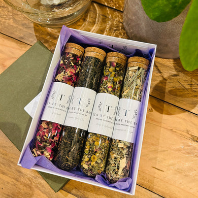 A gift box containing four varieties of organic tea in glass test tubes