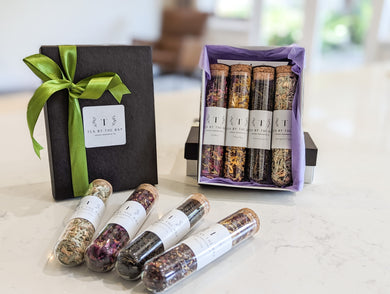 A gift box containing four varieties of organic tea in glass test tubes